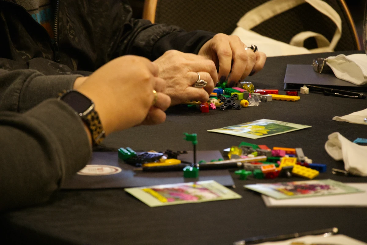 hands-lego-bricks-seed-packets Hands arranging LEGO bricks beside seed packets during a workshop activity